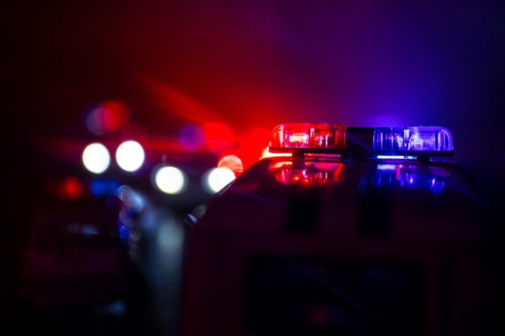 Police car with siren and lights flasher ready for duty City lights on the background